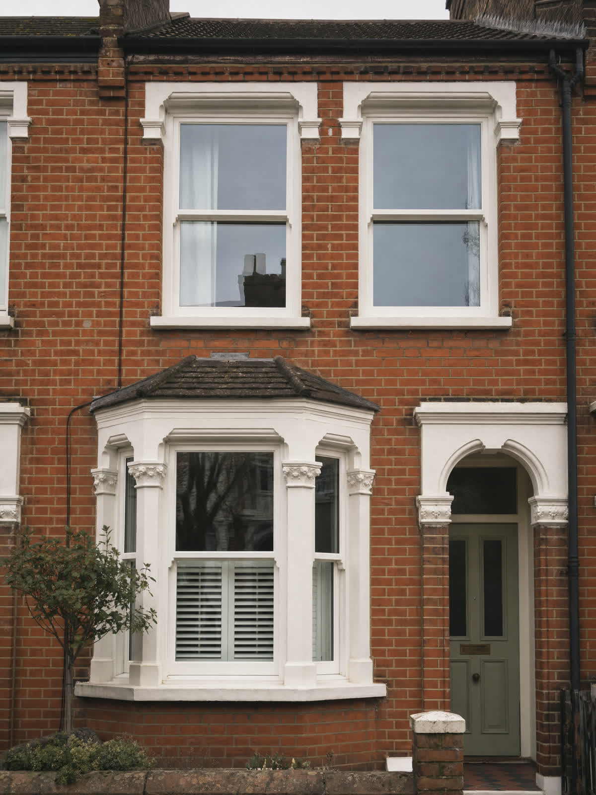 White vertical sliding sash windows on a Victorian red-brick terrace